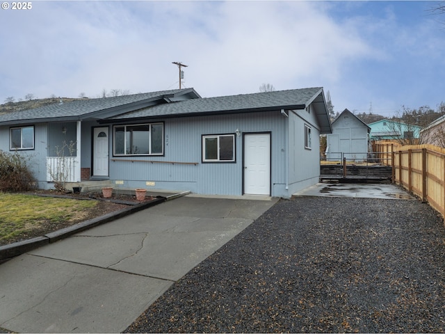 back of property featuring roof with shingles and fence