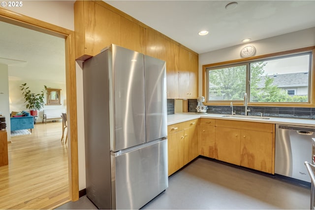 kitchen featuring decorative backsplash, appliances with stainless steel finishes, a sink, light countertops, and recessed lighting