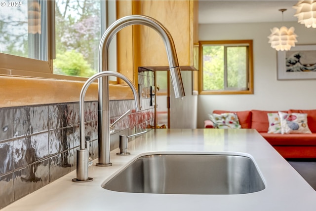 details featuring light countertops, decorative light fixtures, and a sink