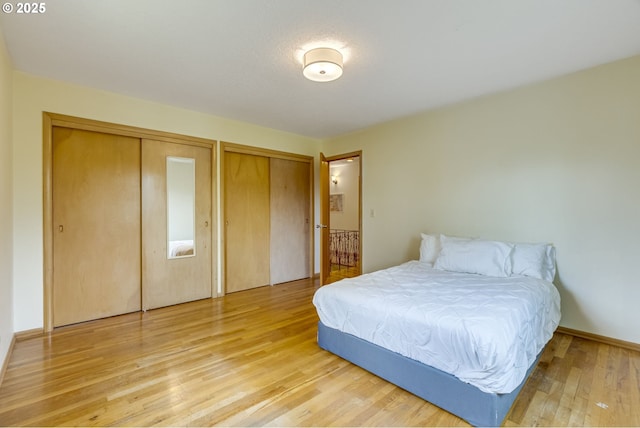 bedroom featuring multiple closets and light wood-type flooring