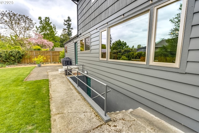 view of home's exterior with a lawn and fence