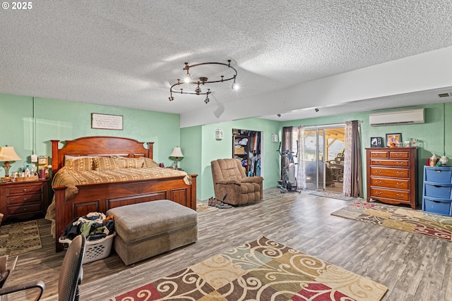1997 Hazel St, Myrtle Point, OR 97458 - bedroom with an AC wall unit, wood finished floors, access to exterior, and a textured ceiling