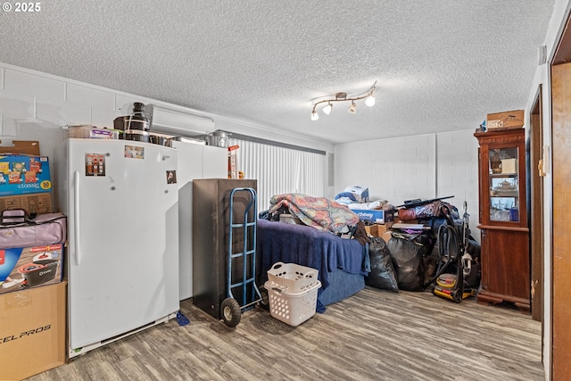 1997 Hazel St, Myrtle Point, OR 97458 - basement with freestanding refrigerator, wood finished floors, concrete block wall, and a textured ceiling
