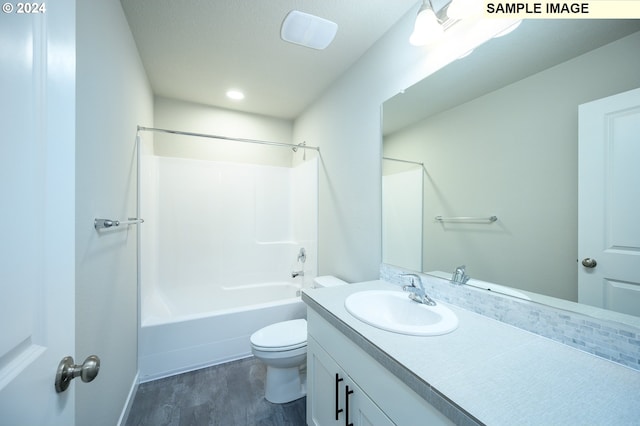 bathroom with toilet,  shower combination, wood finished floors, and vanity