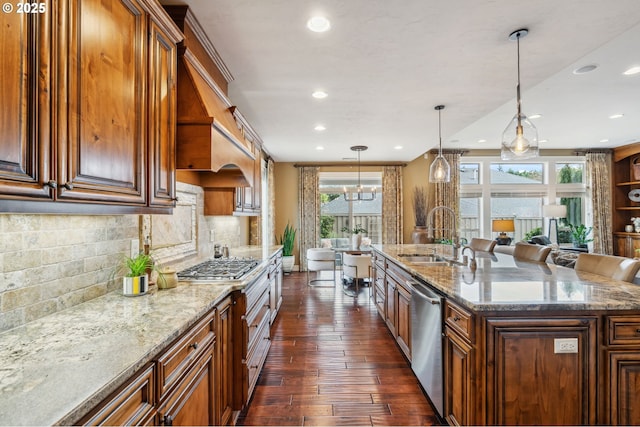 kitchen featuring light stone countertops, appliances with stainless steel finishes, dark wood-style flooring, a sink, and backsplash