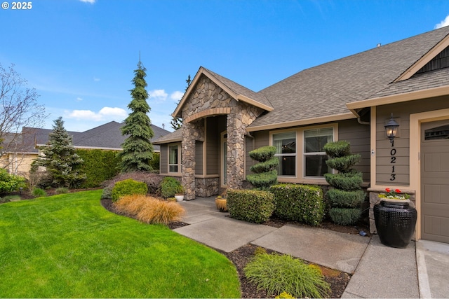 view of front facade featuring roof with shingles, stone siding, and a front lawn