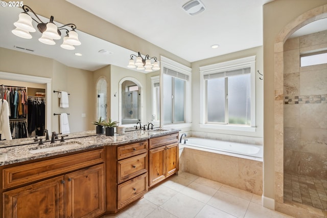 full bathroom with tile patterned flooring, tiled shower, a bath, visible vents, and a sink