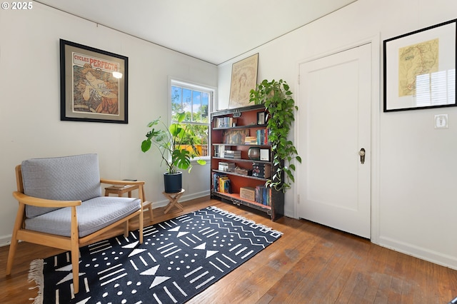 living area with baseboards and hardwood / wood-style flooring