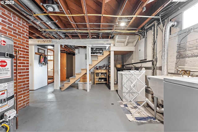 basement with stairway, strapped water heater, electric panel, and washer / clothes dryer