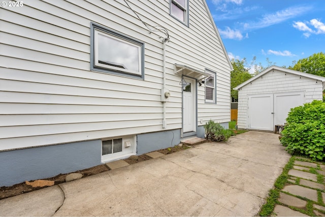 exterior space featuring a storage unit, an outbuilding, and a patio area