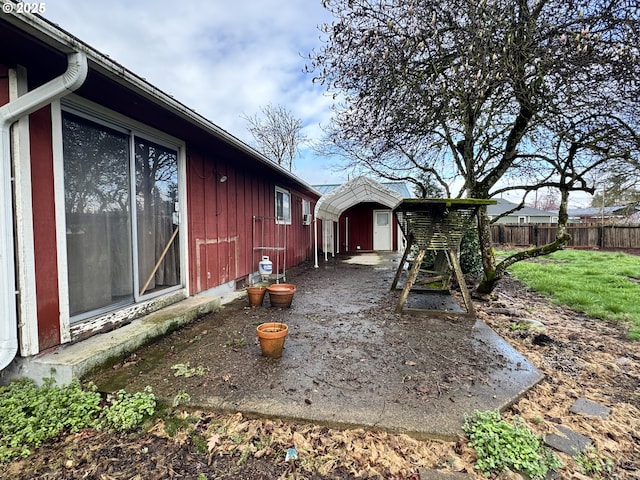 view of yard featuring a storage unit, an outbuilding, and fence