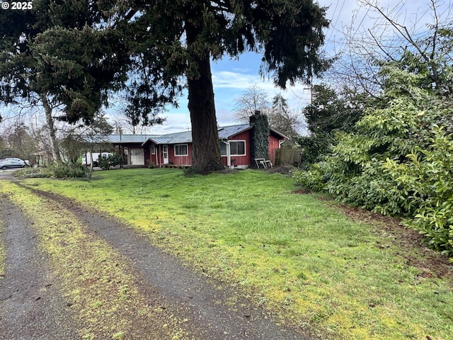 view of front of home with a front yard, fence, and a chimney