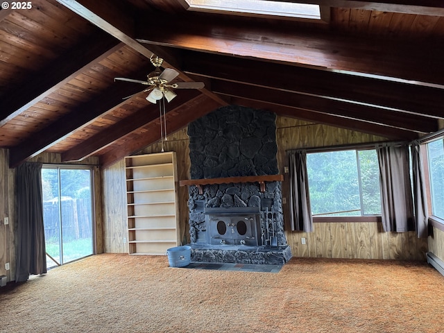 unfurnished living room featuring wooden walls, carpet flooring, wood ceiling, and vaulted ceiling with beams