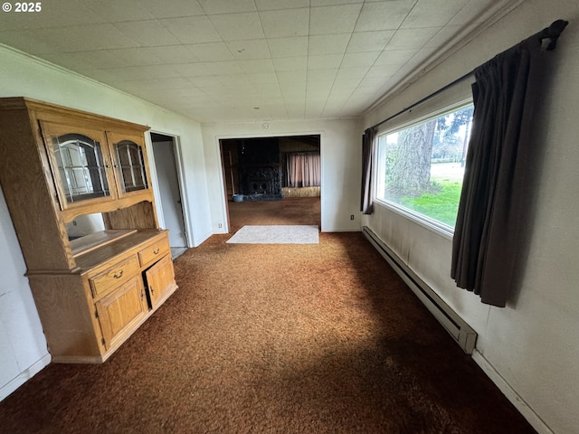 unfurnished living room featuring baseboard heating, dark carpet, and baseboards