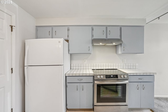 6250 SW 152nd Ave, Beaverton, OR 97007 - kitchen with freestanding refrigerator, stainless steel electric range, under cabinet range hood, gray cabinetry, and tile countertops
