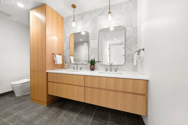 bathroom with double vanity, backsplash, toilet, and a sink