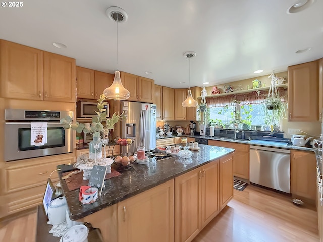 6931 Oakwood Ct, Brookings, OR 97415 - kitchen featuring a center island, decorative light fixtures, a sink, light wood-type flooring, and appliances with stainless steel finishes
