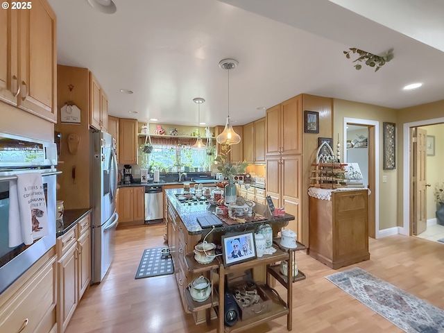 6931 Oakwood Ct, Brookings, OR 97415 - kitchen featuring dark stone countertops, light wood-style flooring, a center island, open shelves, and appliances with stainless steel finishes