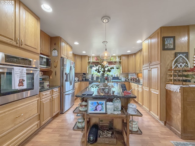 6931 Oakwood Ct, Brookings, OR 97415 - kitchen featuring light wood-style flooring, appliances with stainless steel finishes, dark stone counters, and recessed lighting