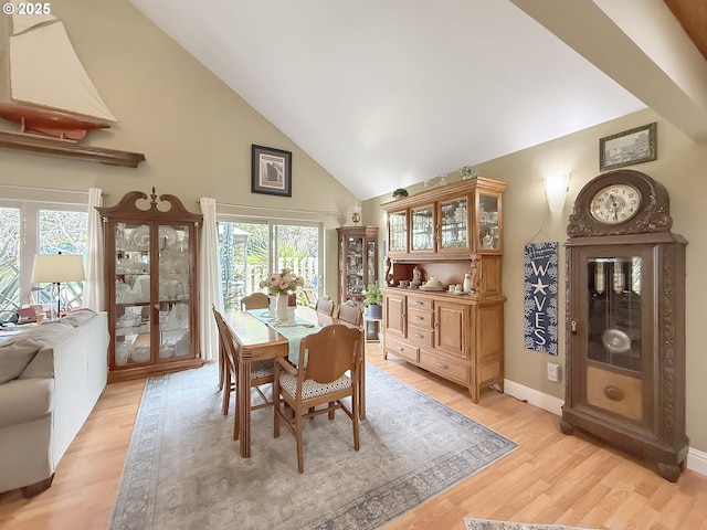 6931 Oakwood Ct, Brookings, OR 97415 - dining area with baseboards, high vaulted ceiling, light wood-style floors, and a healthy amount of sunlight