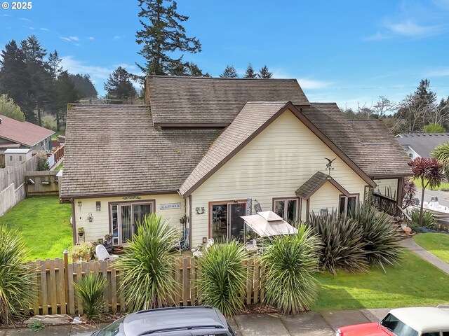 6931 Oakwood Ct, Brookings, OR 97415 - view of front facade with a front yard, fence private yard, and roof with shingles