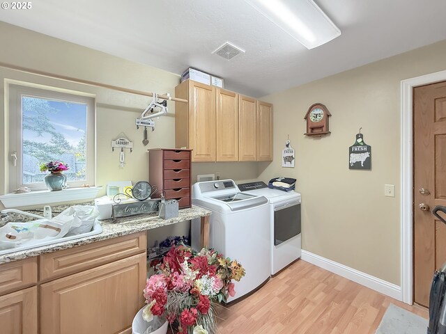 6931 Oakwood Ct, Brookings, OR 97415 - laundry area with light wood-style floors, cabinet space, visible vents, and washer and clothes dryer
