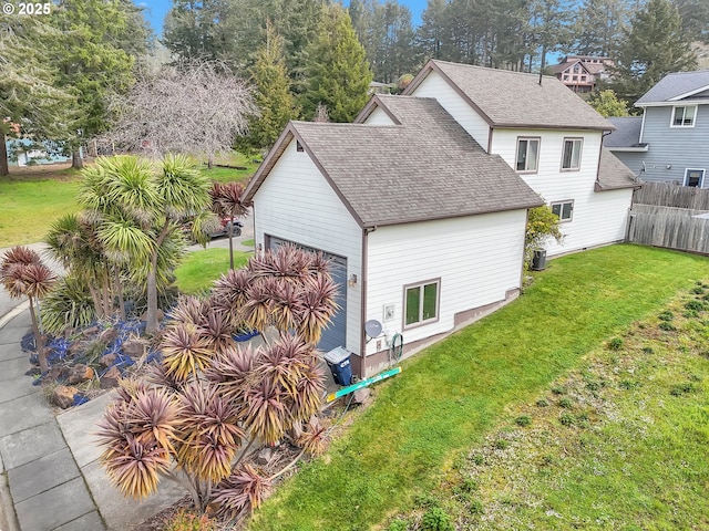 6931 Oakwood Ct, Brookings, OR 97415 - back of property with a garage, a shingled roof, fence, and a lawn