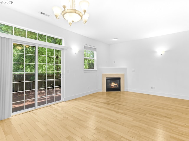 15235 SW Jasper Ln, Beaverton, OR 97007 - unfurnished living room featuring a chandelier, wood finished floors, and a glass covered fireplace