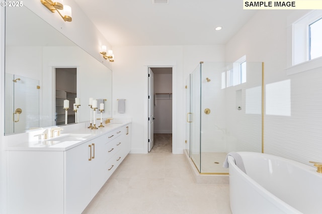 full bathroom featuring a stall shower, double vanity, and a spacious closet