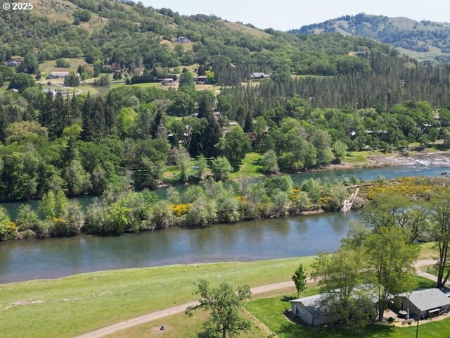 1104 Rio Nes Ln, Roseburg, OR 97470 - aerial view of property and surrounding area featuring a heavily wooded area and a water and mountain view