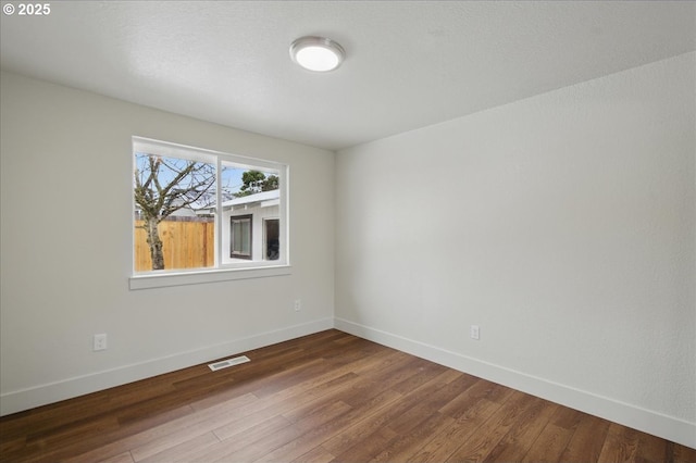 empty room featuring dark hardwood / wood-style flooring