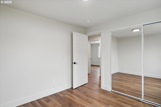 unfurnished bedroom with wood-type flooring and a closet