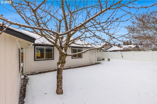 view of snow covered back of property