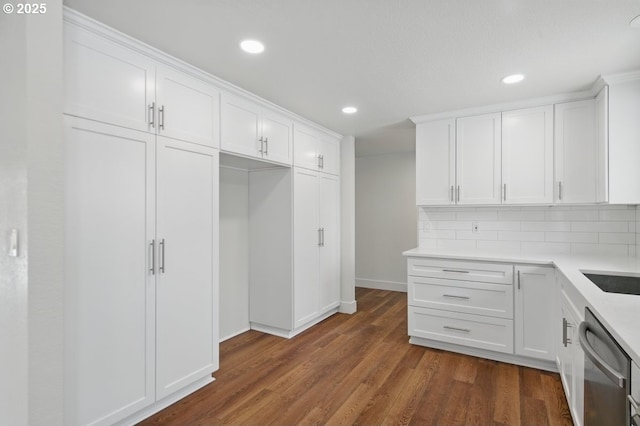 kitchen featuring white cabinets, stainless steel dishwasher, and tasteful backsplash