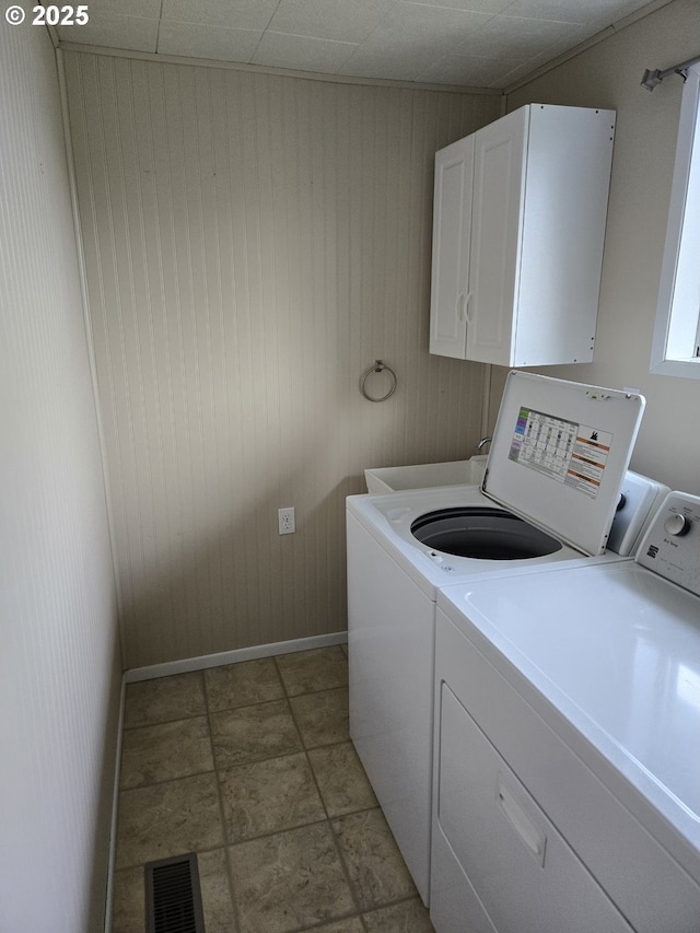 clothes washing area featuring baseboards, cabinet space, independent washer and dryer, and visible vents