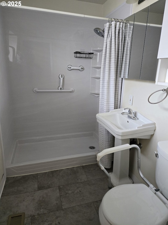 bathroom with toilet, visible vents, and a stall shower