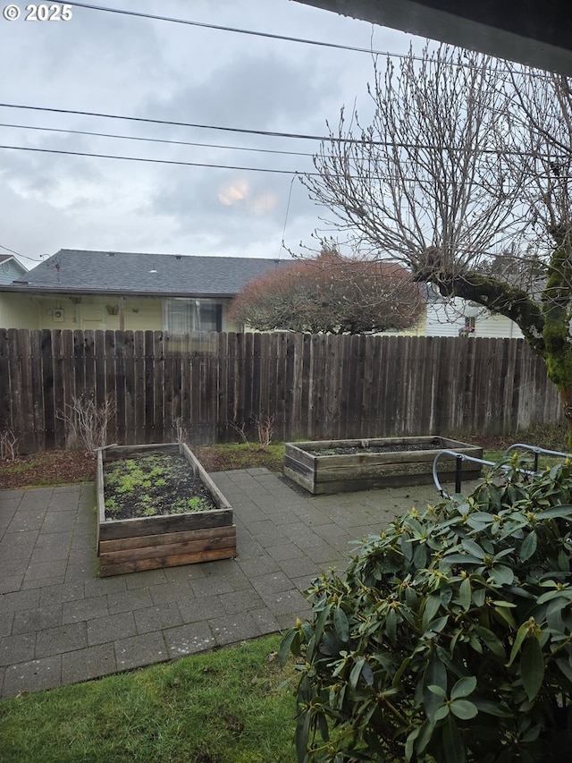 view of yard with fence, a garden, and a patio