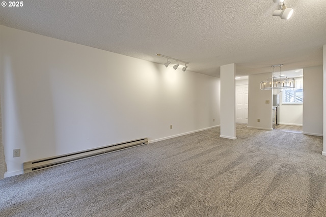 carpeted empty room with track lighting, a baseboard radiator, and a textured ceiling