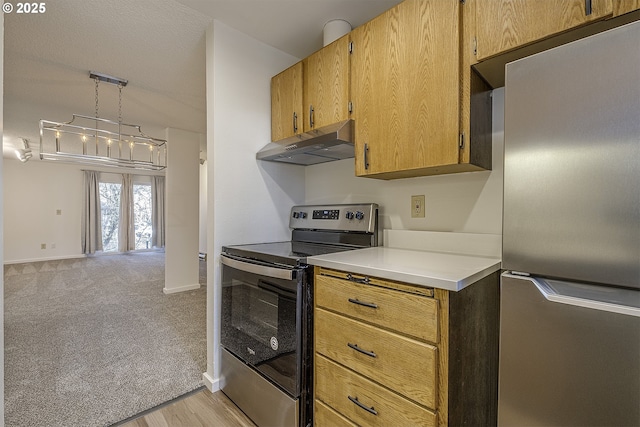 kitchen with decorative light fixtures, light colored carpet, and appliances with stainless steel finishes