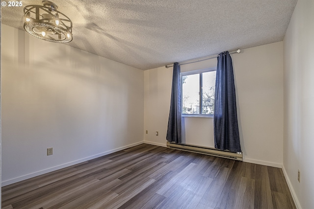 spare room featuring a chandelier, a baseboard heating unit, dark hardwood / wood-style floors, and a textured ceiling