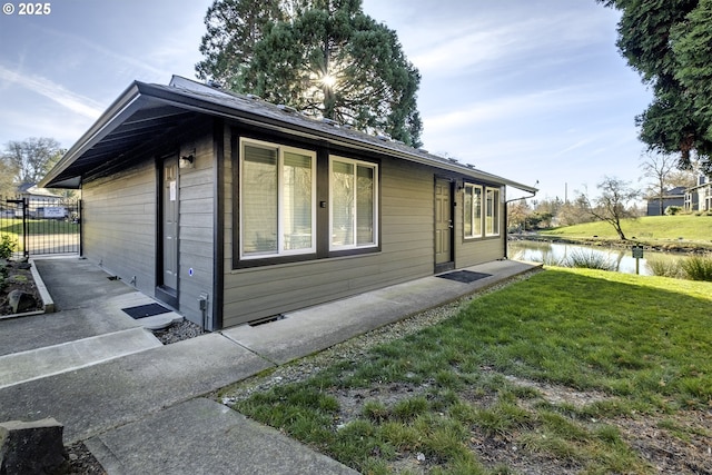 view of side of property with a yard and a water view