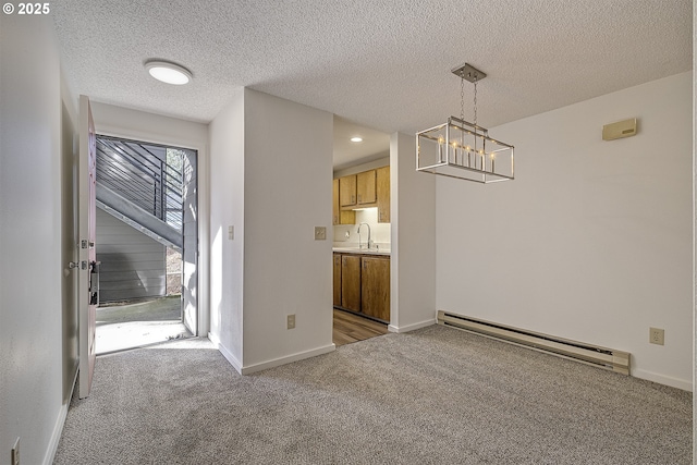 unfurnished dining area with baseboard heating, light colored carpet, sink, and a textured ceiling