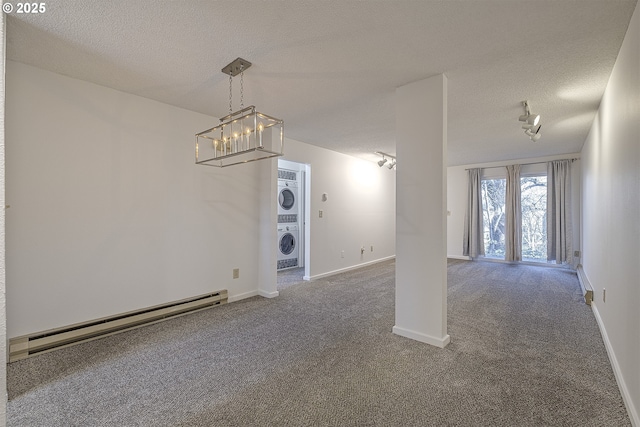 interior space with a baseboard radiator, a textured ceiling, stacked washer and clothes dryer, and dark colored carpet