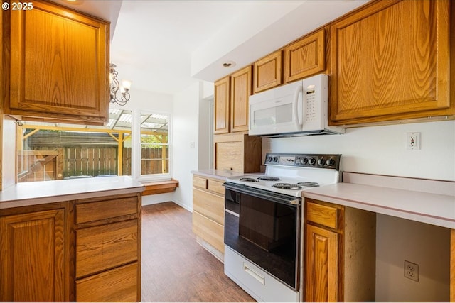 3315 SE 15th Ave, Portland, OR 97202 - kitchen featuring white microwave, range with electric stovetop, light countertops, brown cabinetry, and dark wood-style flooring