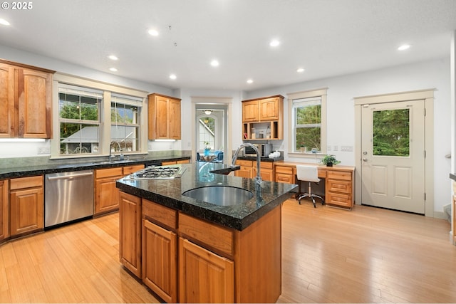 kitchen with light wood-type flooring, recessed lighting, stainless steel dishwasher, a sink, and an island with sink