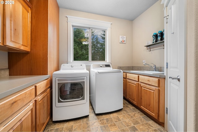 laundry area with cabinet space, a sink, and independent washer and dryer