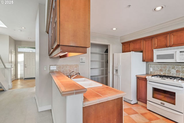 kitchen featuring sink, backsplash, ornamental molding, kitchen peninsula, and white appliances