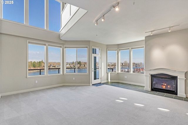 unfurnished living room with a skylight, carpet, and a water view