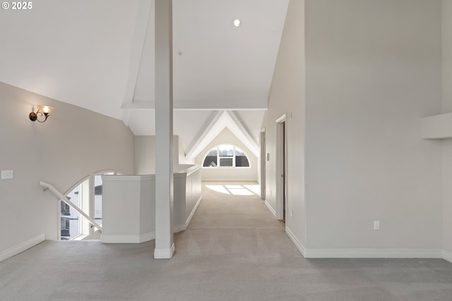 hall with lofted ceiling and light colored carpet