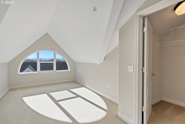 additional living space with vaulted ceiling and light carpet